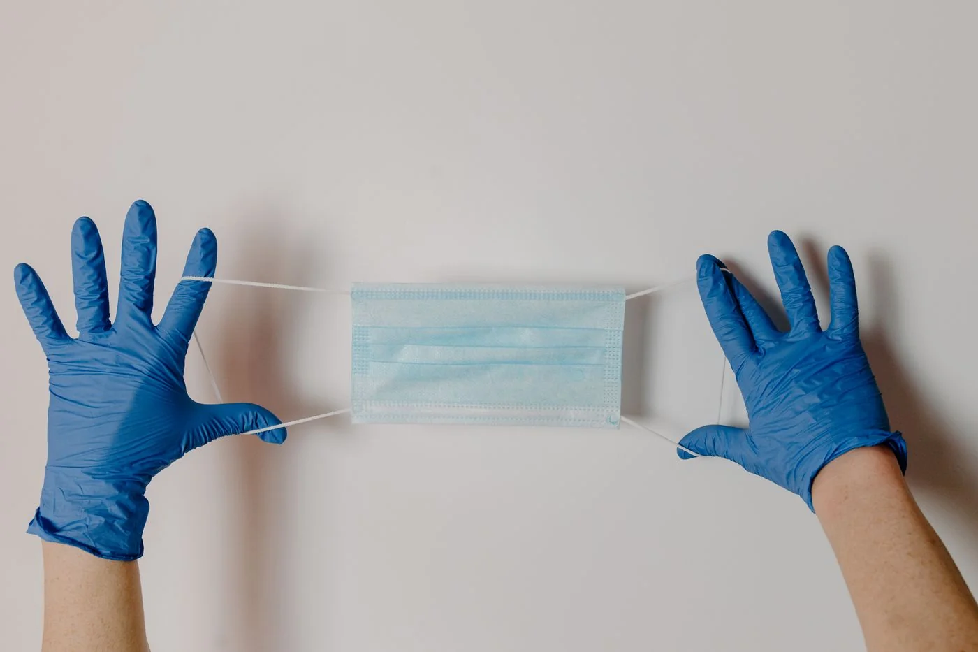 Gloved hands with a disposable surgical mask